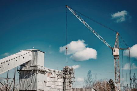 Construction site with crane and building materials under blue sky