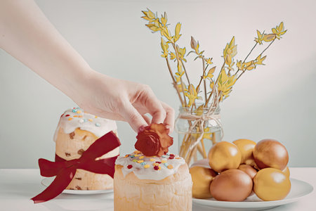 A festive Easter scene featuring a hand decorating a small cake with a strawberry, accompanied by a...