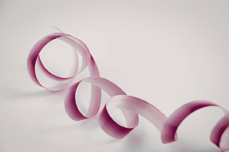 Pink ribbon curls on white background for decoration