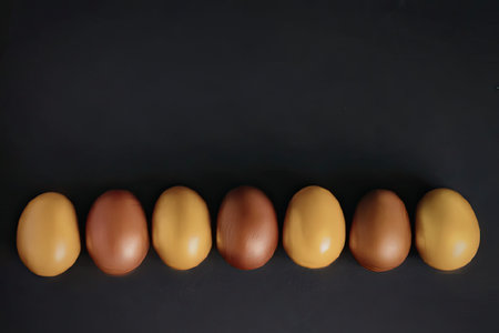 Row of colorful eggs on dark background