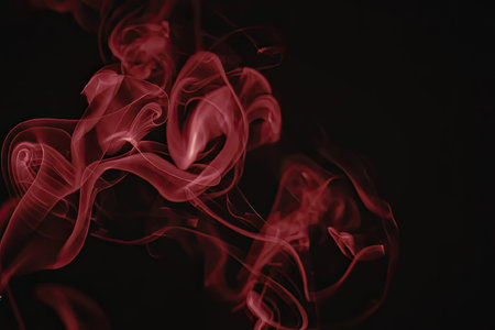 An image of red smoke swirling against a dark background, creating a mesmerizing visual effect.