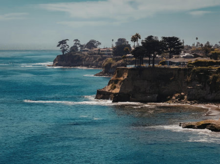 A scenic view of a rocky coastline with trees and waves crashing against the shore.