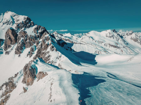 A breathtaking landscape of snow-covered mountains and a glacier under a clear blue sky.