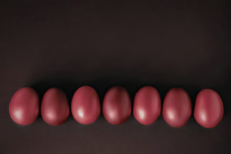 An image of seven eggs arranged horizontally against a dark backgroundの写真素材