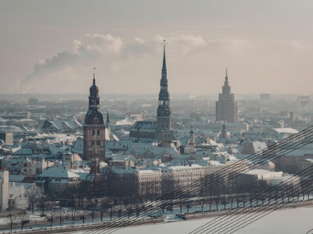 Aerial view of a snow-covered city with historic buildings and spires under a cloudy skyの写真素材