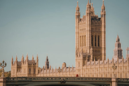 The image depicts the Houses of Parliament in London, showcasing its Gothic Revival architecture and iconic clock tower, set against a clear blue sky.の写真素材
