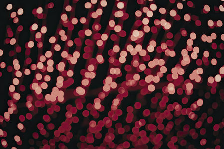 The image depicts a mesmerizing display of red and pink lights scattered against a dark backdrop,...