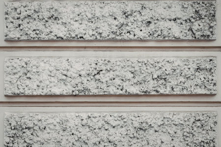 Three rectangular gray granite tiles with a speckled pattern, separated by thin brown lines on a...
