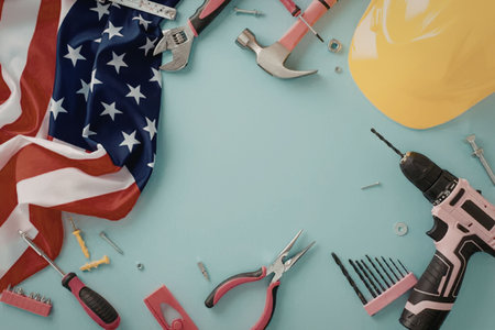 A collection of tools and a hard hat on a blue background with an American flag