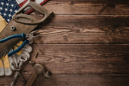 A selection of workbench tools on a wooden background with an American flag