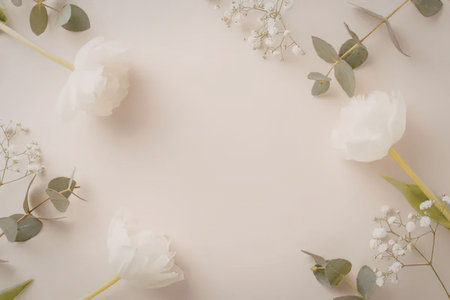 A serene arrangement of white flowers and green leaves on a soft pink background, creating a peaceful and elegant visual composition.の写真素材