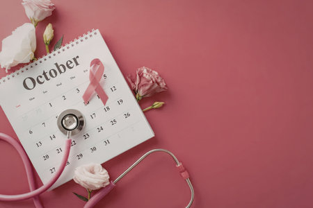 A calendar page for October with a pink ribbon, stethoscope, and flowers on a pink background, symbolizing Breast Cancer Awareness Month.の写真素材