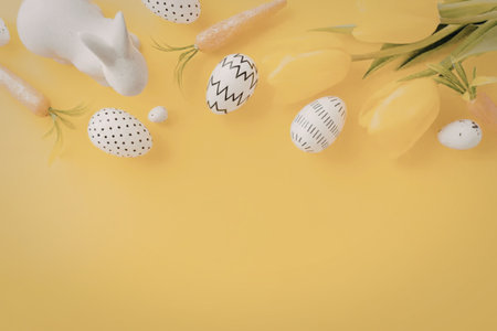 A bright yellow background with Easter eggs, tulips, and carrots arranged on it.