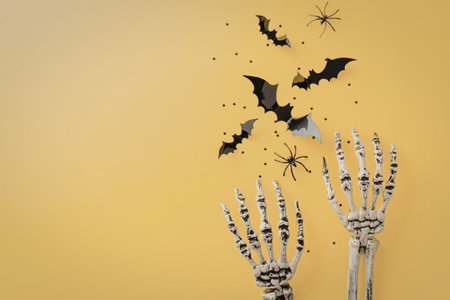 A skeleton hand raised up with black bats and spiders on a yellow background