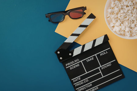 A movie clapper board, 3D glasses, and a bowl of popcorn on a colorful background
