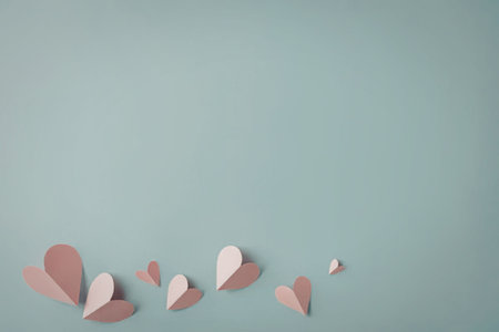 A collection of pink paper hearts on a light blue background