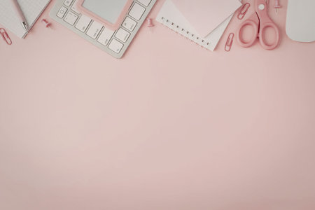 A pink workspace with a keyboard, scissors, and other office supplies
