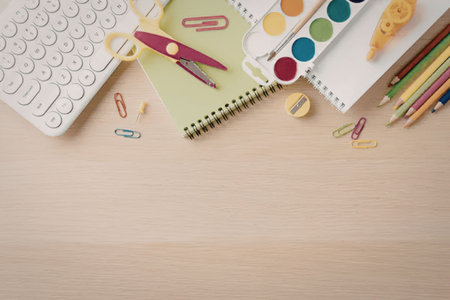 A collection of school supplies including a keyboard, scissors, notebooks, paint palette, pencils,...