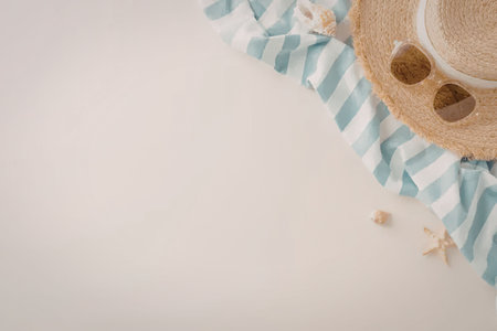 A straw hat, sunglasses, and starfish on a blue and white striped cloth