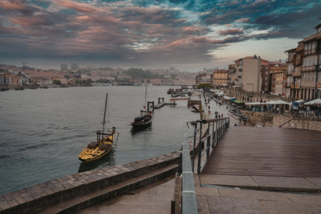 A serene waterfront scene at sunset, featuring a dock, boats, and a city skyline in the background.