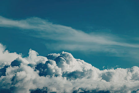 The image captures a serene scene of white, fluffy clouds floating against a vibrant blue sky.