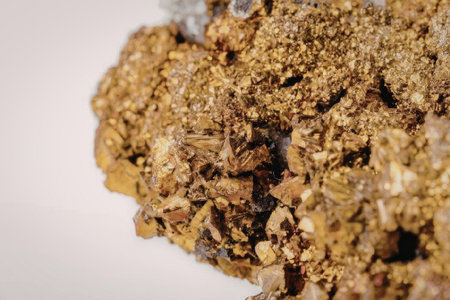 A close-up view of a gold ore chunk with a rough texture, set against a plain white background, showcasing its natural, earthy appearance.
