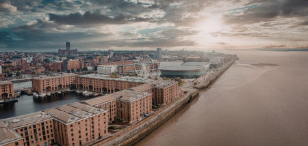 An aerial view of a city situated by a large body of water, with a row of buildings and a cloudy sky.
