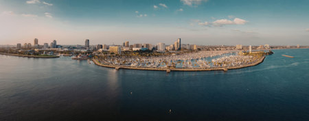 A panoramic view of a city situated by the water, showcasing its skyline and waterfront area during sunset.