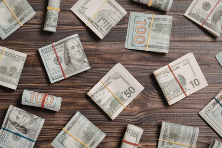 Image of multiple bundles of pound sterling banknotes arranged on a dark wooden surface, symbolizing wealth and financial transactions.