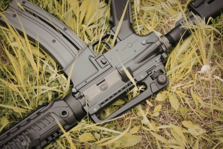 A black rifle is lying in the grass, possibly an AK-47 or similar model, with visible magazine and stock.