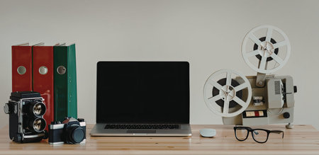 A collection of vintage film and computer equipment on a wooden desk