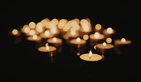 This image features a collection of lit tea candles in the dark, creating a warm and cozy ambiance.