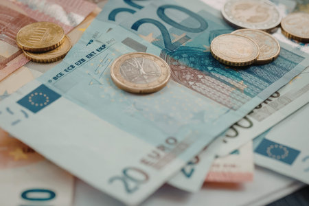 A close-up view of euro banknotes and coins, with a focus on the 20 euro note.
