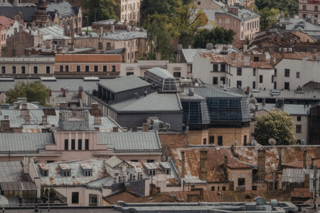 Urban landscape featuring a mix of old and new buildings with various rooftops and satellite dishes in a cityscape with trees surrounding the structures.