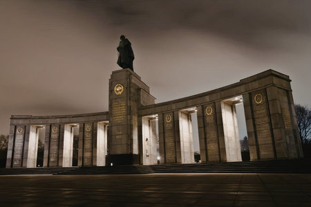 a large building with a statue on top of it. the building has several columns and a large tower in the center. the sky is cloudy and dark.