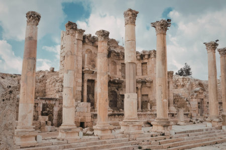 a low resolution photo of several tall columns standing upright in front of a cloudy sky with some blue peeking through the clouds the columns are tall and thin with intricate carvings at the top they are spaced out in a line and appear to be made of stone or marble the sky above them is mostly cloudy with some patches of blue visible through the gaps in the clouds