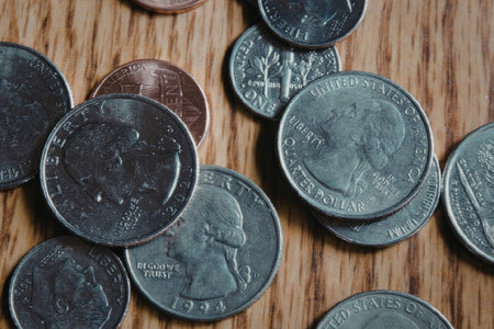 A collection of coins scattered on a wooden table or floor