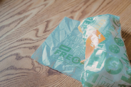 A frozen food bag on a wooden table, with green and orange text.