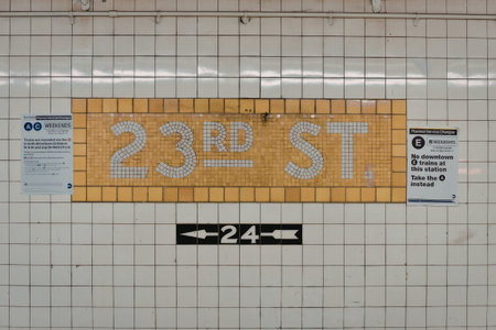a brown sign on a white tiled wall with gray letters that says 23rd st and a black sign below with white arrows and the number 24
