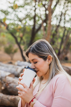 Close-up of young woman drinking in the forest