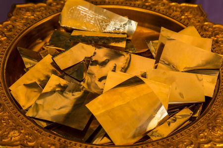 The golden sheet on tray with pedestal  For people who want to make merit must write the name down on this thingの写真素材