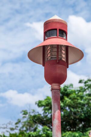 The vintage, retro, ancient lamppost at the park colored redの写真素材