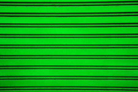 Green steel roller shutter door background garage door with horizontal linesの写真素材