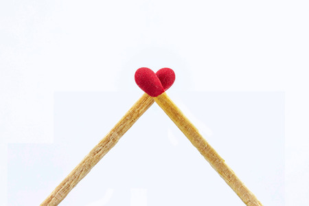 Close up matchsticks heart shaped on white background.