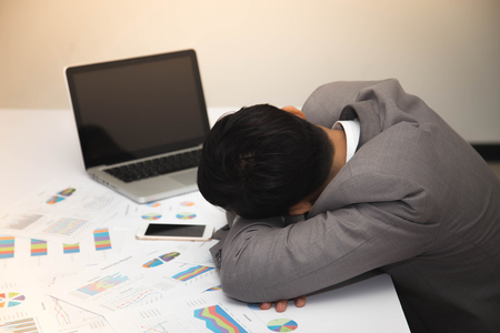 Businessman is sleeping on workdesk.の写真素材