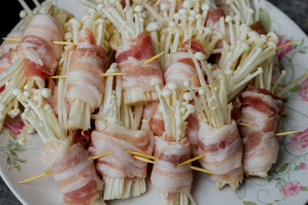 Golden needle mushrooms grilled baconの写真素材
