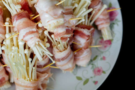 Golden needle mushrooms grilled baconの写真素材
