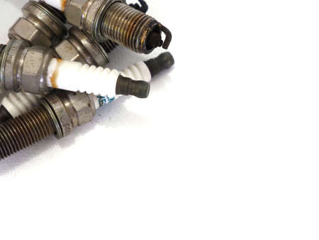 Photo of engine spark plugs on a white background.