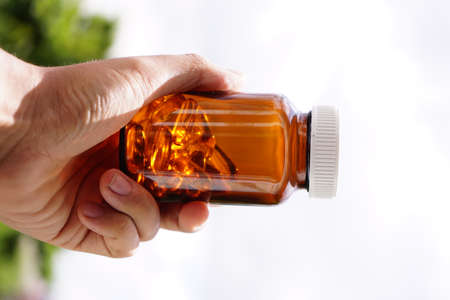 Omega-3 cod liver oil in a white container and with a white background picture.の写真素材