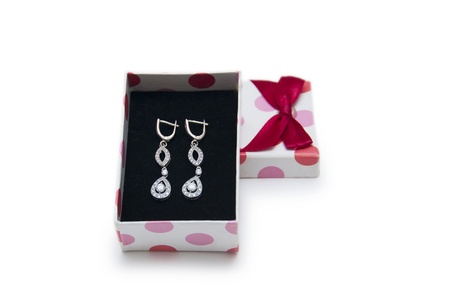Silver earrings in a box isolated on white background の写真素材